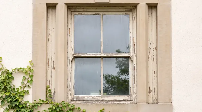 BEFORE photo — single-glazed wood window, flaking paint